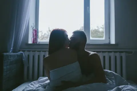 Para kochająca się w łóżku, w intymnej pozycji kurtyzany, przy oknie.