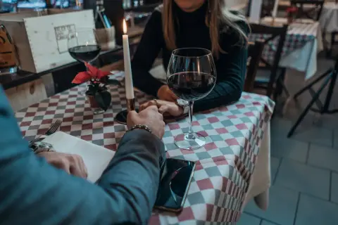 Para przy świecach, wino, dłonie splecione. Czy jemu na mnie zależy? Romantyczny wieczór w restauracji.